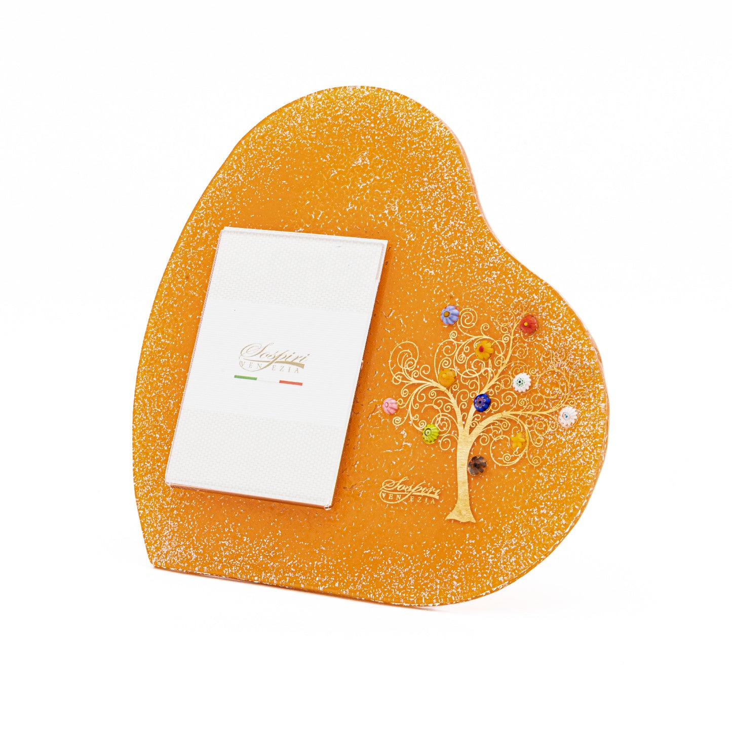 Cornice portafoto arancione a forma di cuore in vetro di Murano con finitura glitterata e Albero della Vita dorato decorato con murrine di Murano colorate, su sfondo bianco.